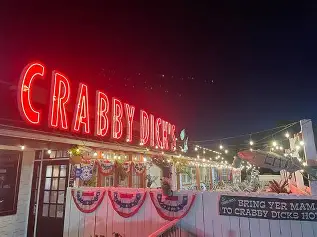 Crabby Dick's neon sign glowing at night on the Rehoboth Beach strip